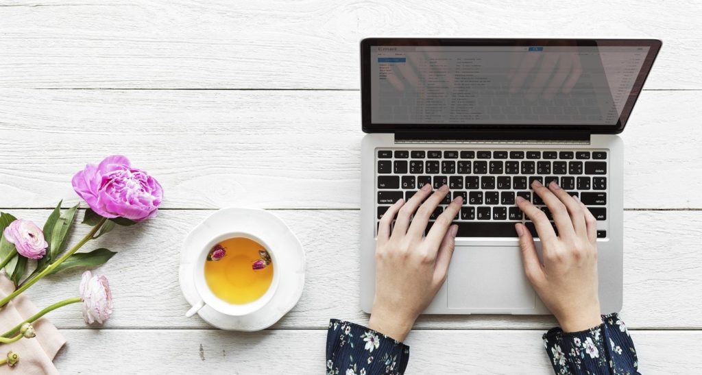 aerial view of a woman using computer laptop working and hot tea drink